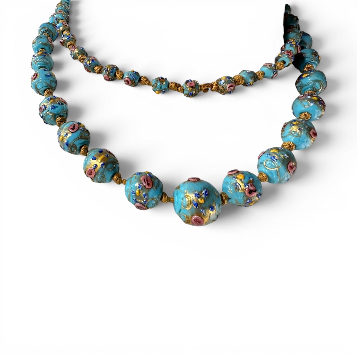 Detail of individual gold-tone cord knots between graduating Murano glass beads with applied floral motifs