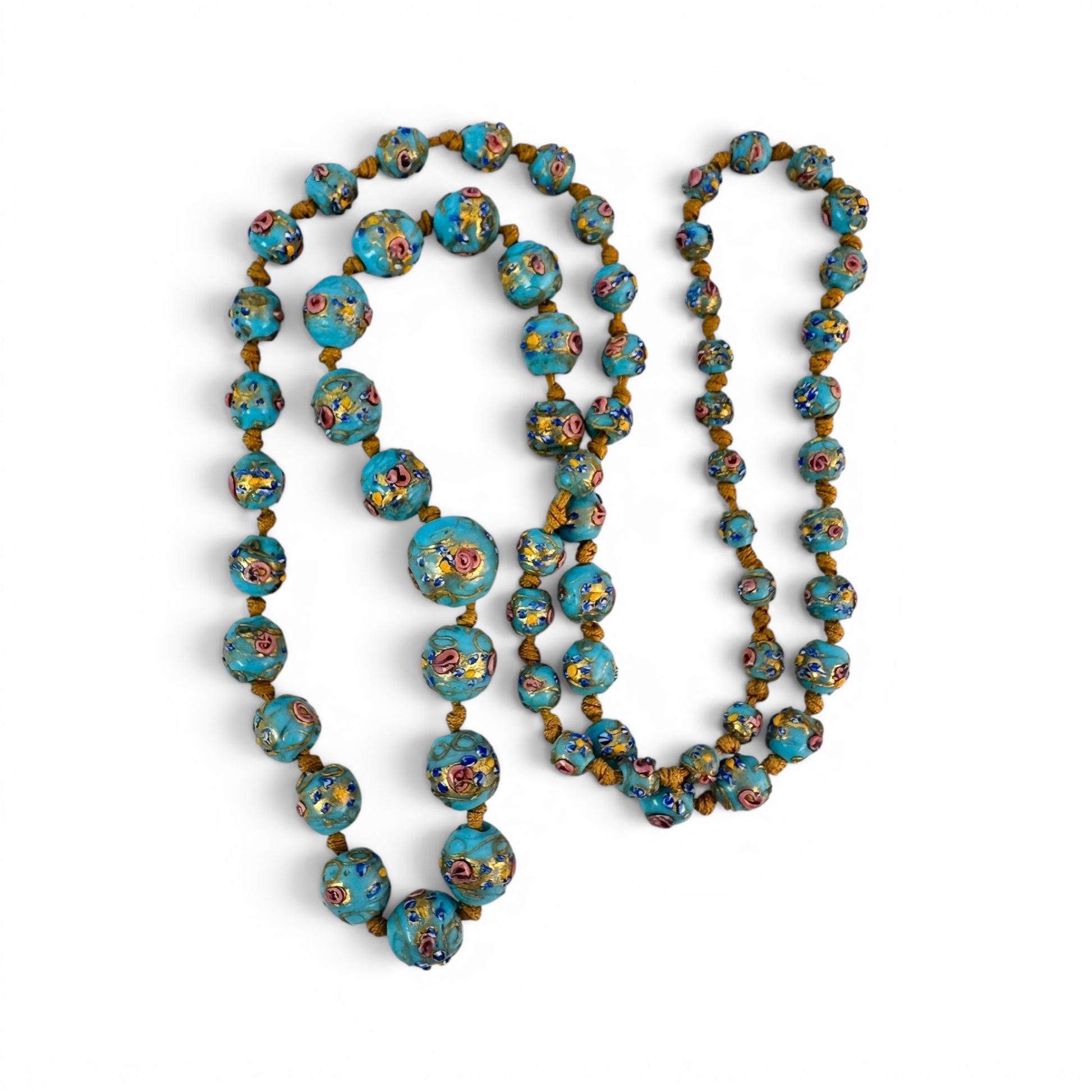 Center section of graduated Murano glass bead necklace showing largest bead with multicolor raised floral decoration and g...