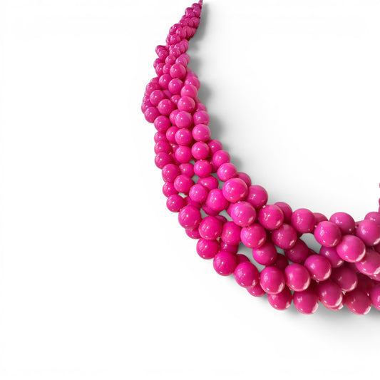 Close-up of glossy fuchsia round acrylic beads in twisted multi-strand formation, approximately five to six strands