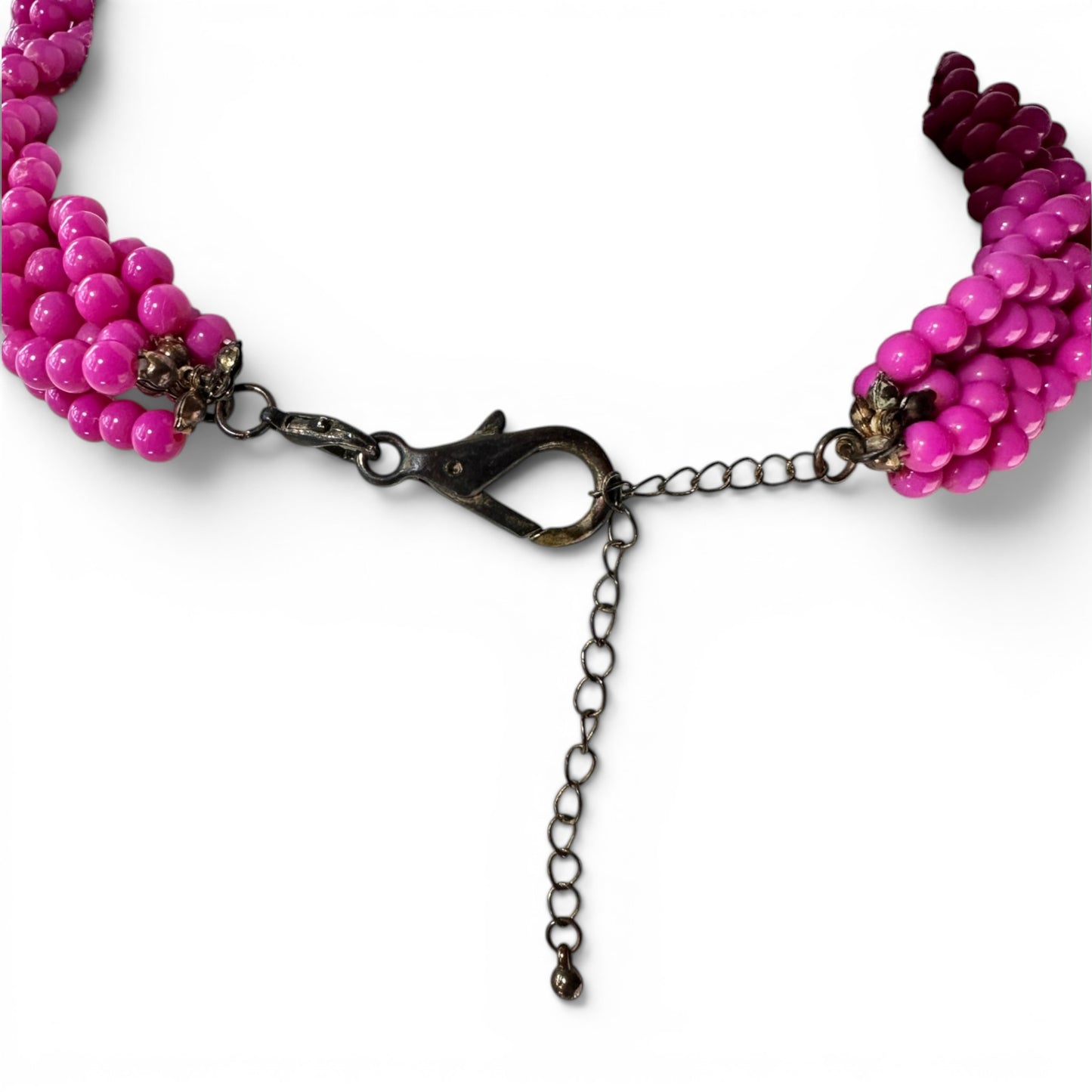 Bead cap terminal detail where multiple hot pink bead strands gather into jump ring and clasp hardware