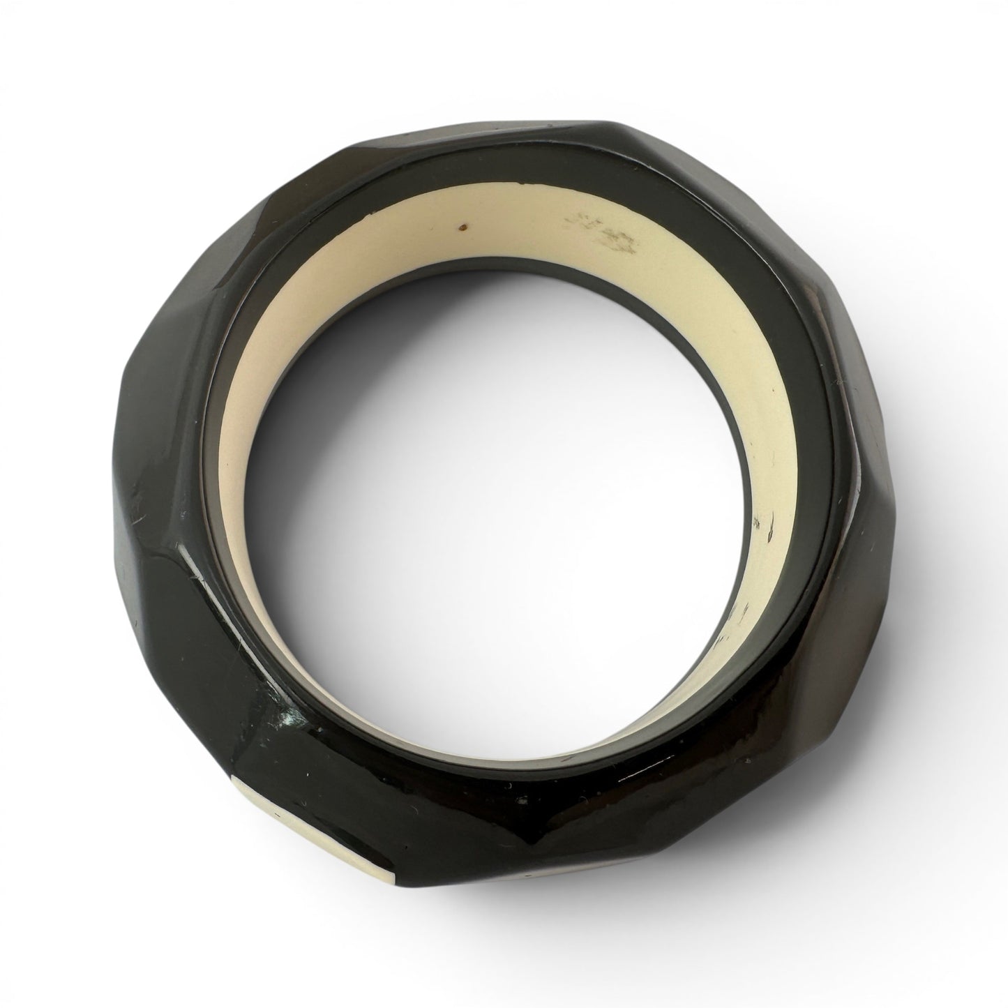 Close-up of faceted black exterior panels with cream polygonal inlays and low-dome angular silhouette
