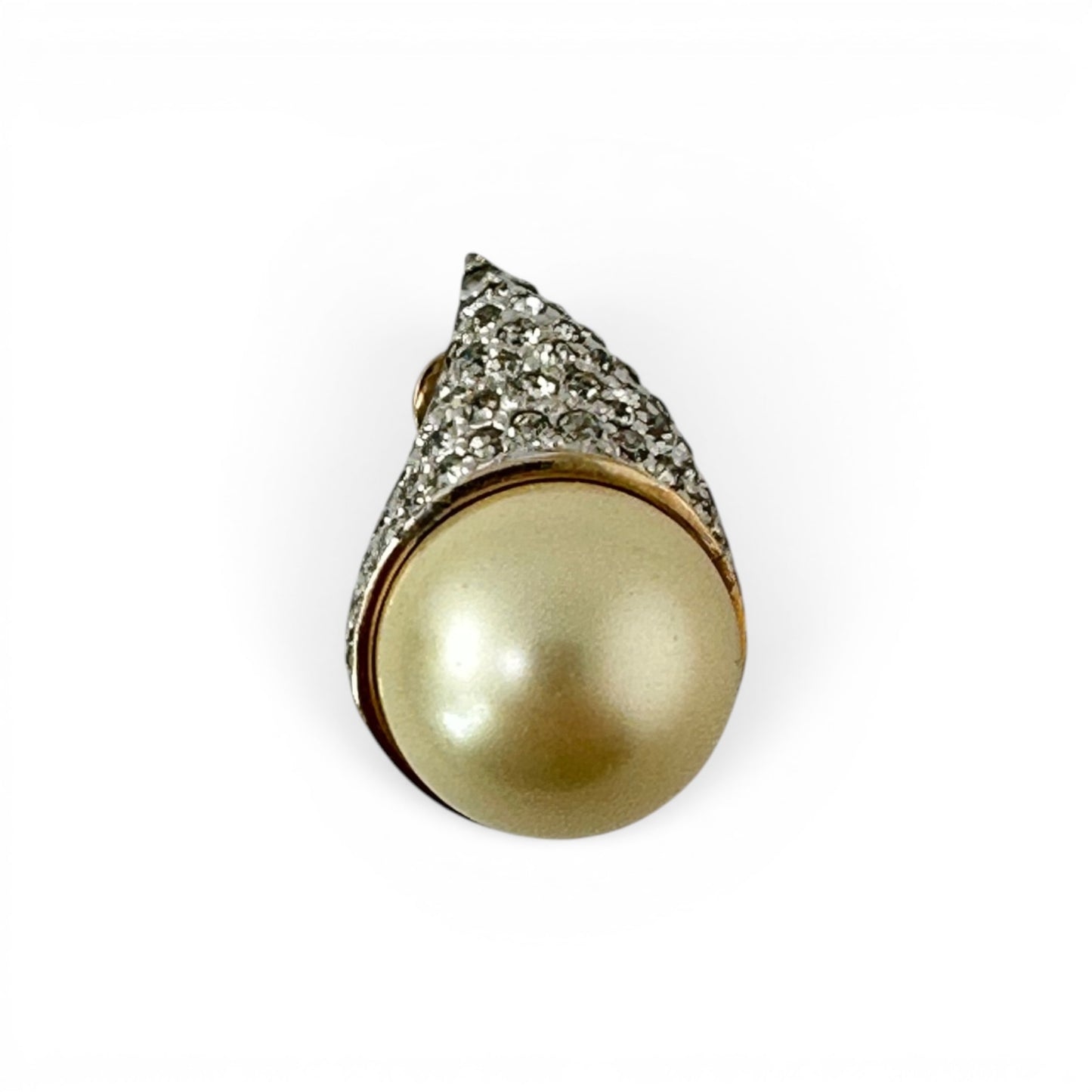 Close-up of pavé-set rhinestone teardrop cap on Panetta clip earring against cream faux pearl base