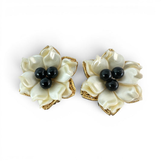 Clip-on floral earrings with layered ivory pearlescent petals and three black bead centers in gold-tone filigree frames, f...