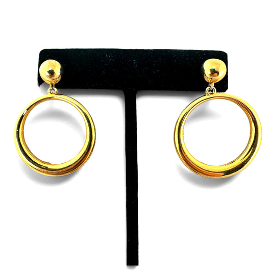 Gold-tone drop earrings with round ball stud top and large open circular tubular hoop pendant, displayed on black velvet T...