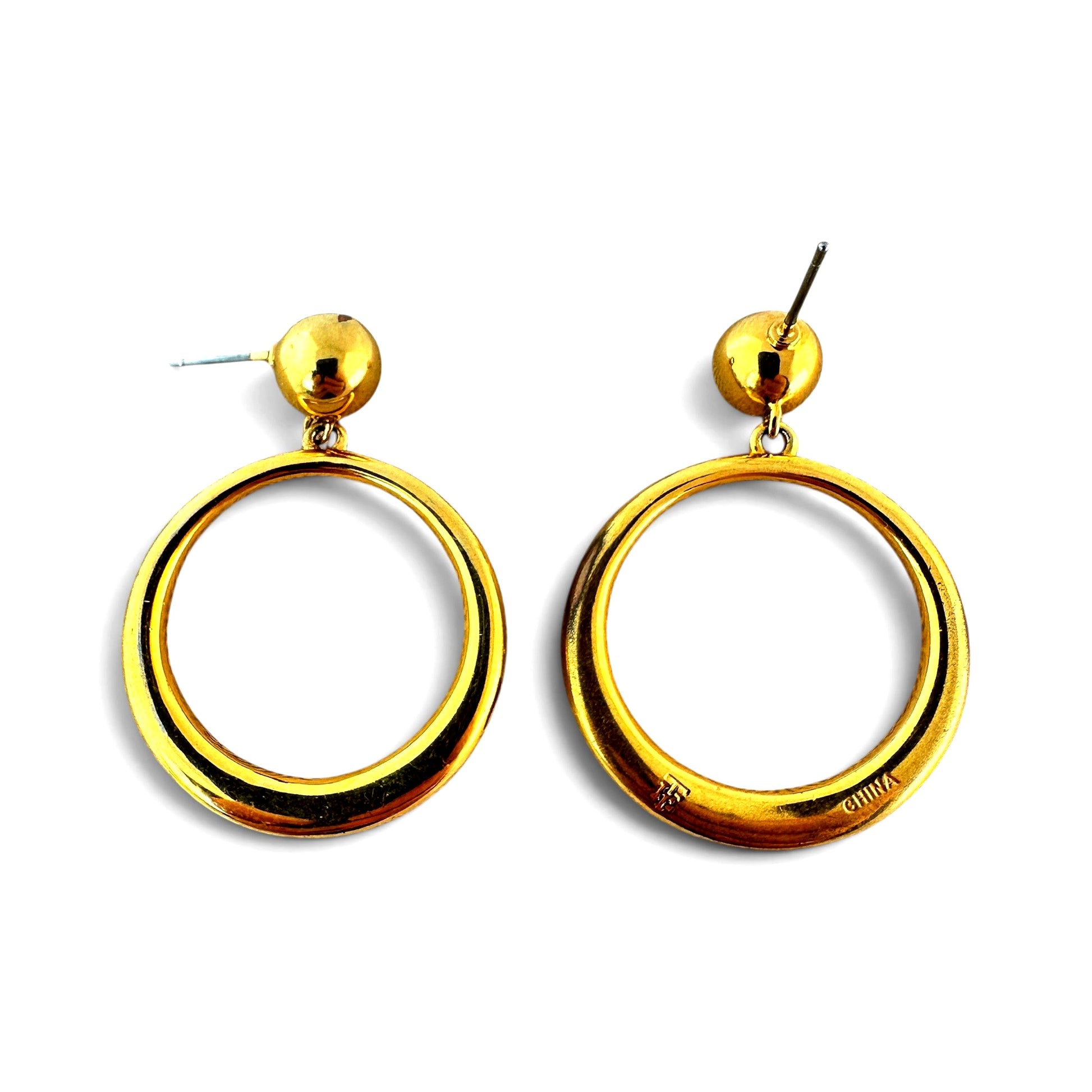 Reverse of gold-tone hoop earring showing stamped mark reading CHINA and partial maker's initial on base metal back