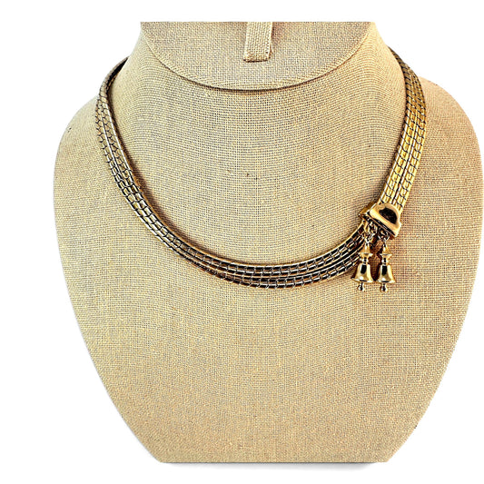 Gold-tone flat snake chain bolo necklace with black enamel rectangular slider and two dangling bell charms, full length view