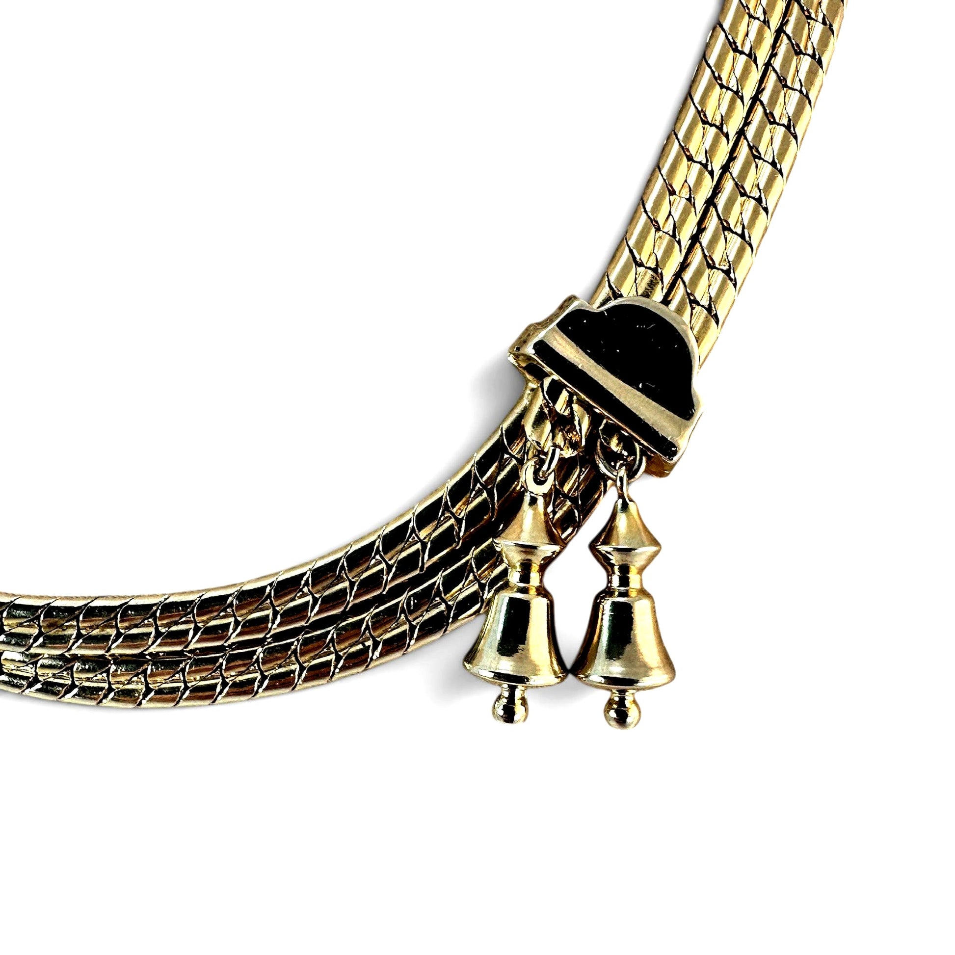 Close-up of black enamel and gold-tone rectangular bolo slider with two small bell charms on short chains