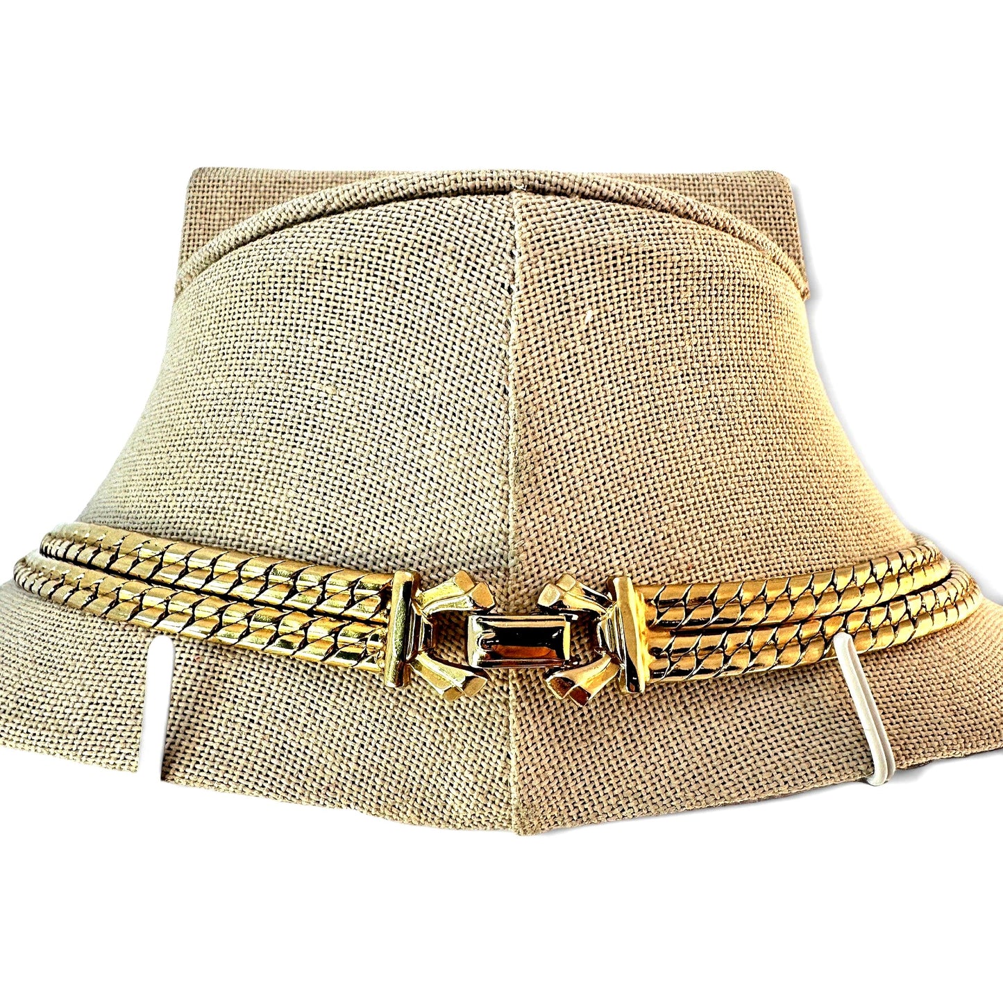 Reverse view of gold-tone snake chain necklace showing polished box clasp with decorative flanged end caps and safety tab