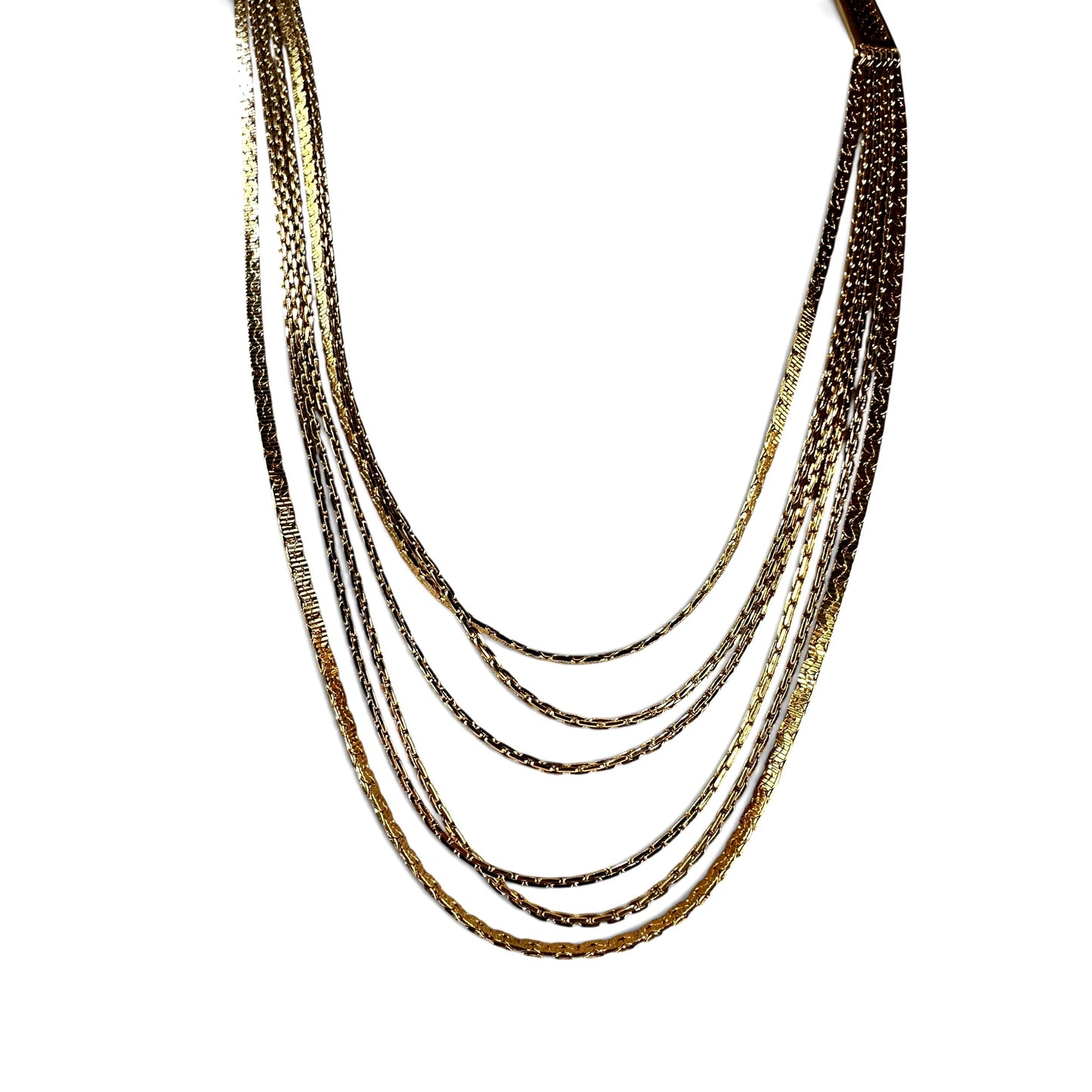 Close-up of rectangular Greek key geometric cut-out box clasp on gold-tone Monet multi-strand necklace