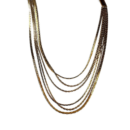 Close-up of rectangular Greek key geometric cut-out box clasp on gold-tone Monet multi-strand necklace