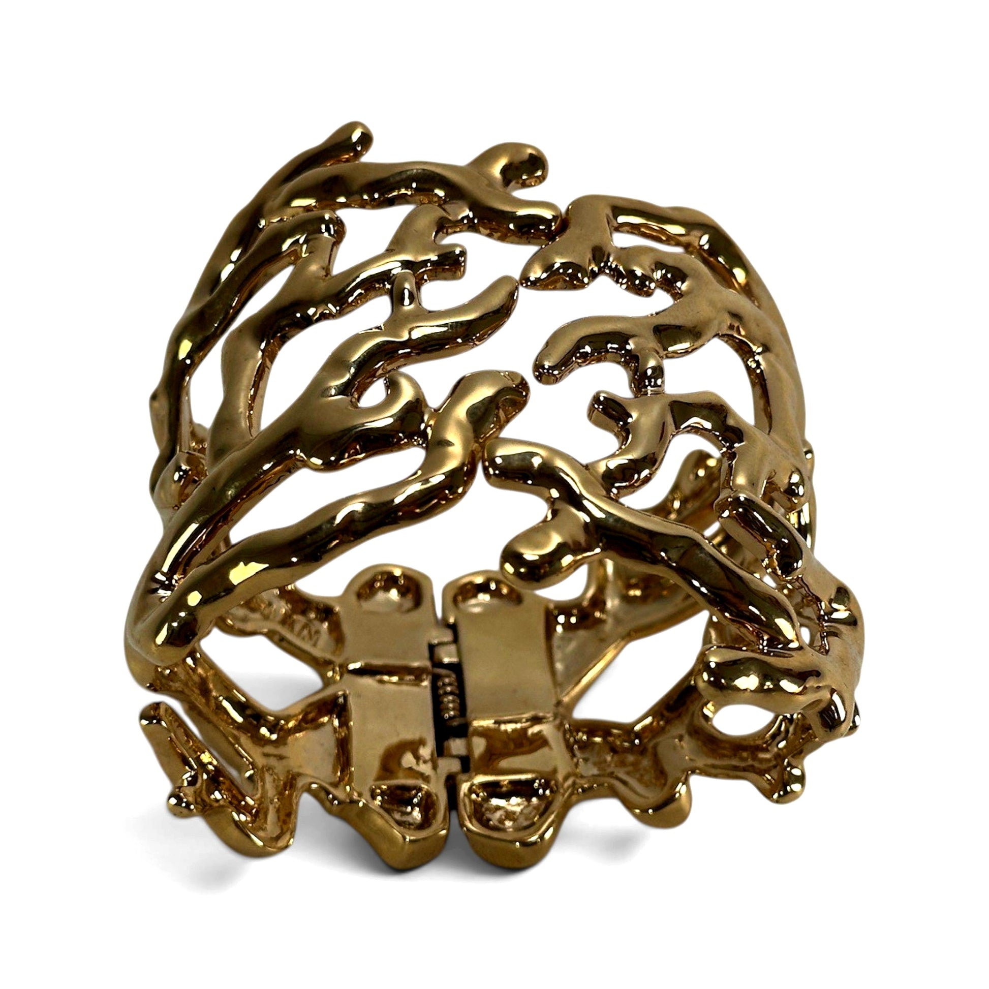 Interior view of gold-tone cuff bracelet showing box-style push-in clasp and two hinge points on clasp side