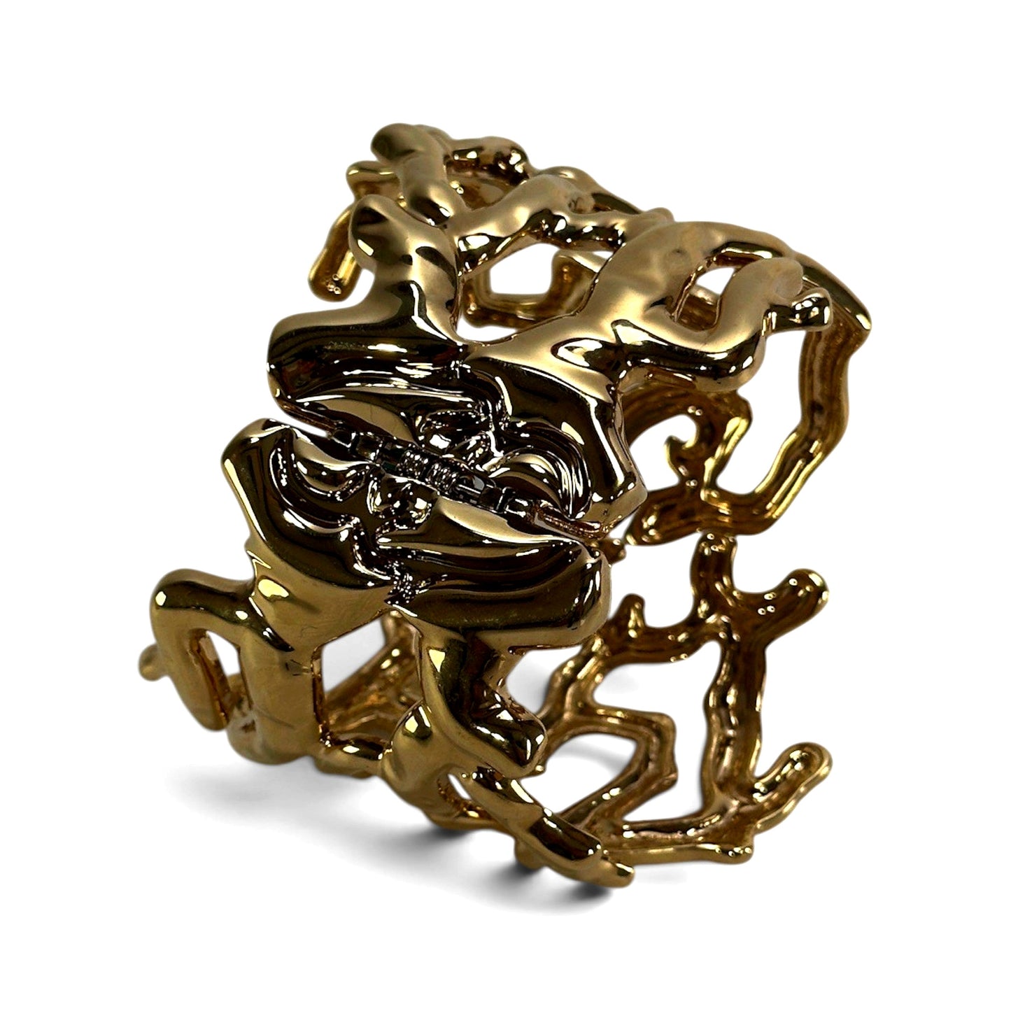 Close-up of openwork branch and coral forms cast in gilt metal on wide hinged clamper cuff bracelet