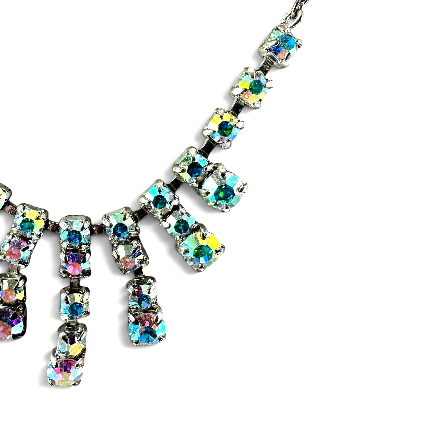 Close-up of aurora borealis rhinestones showing iridescent teal, lavender, and pink flash in open-back cup prong settings