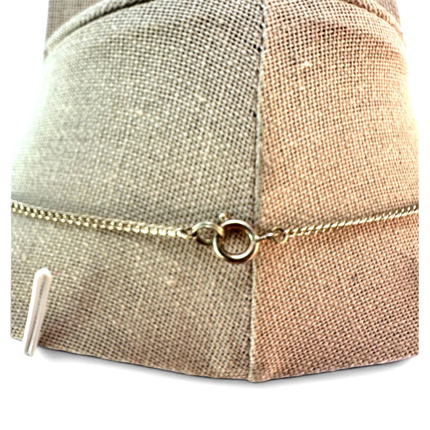 Reverse view of silver-tone necklace showing oxidized base metal settings with patina and green verdigris on prong cups