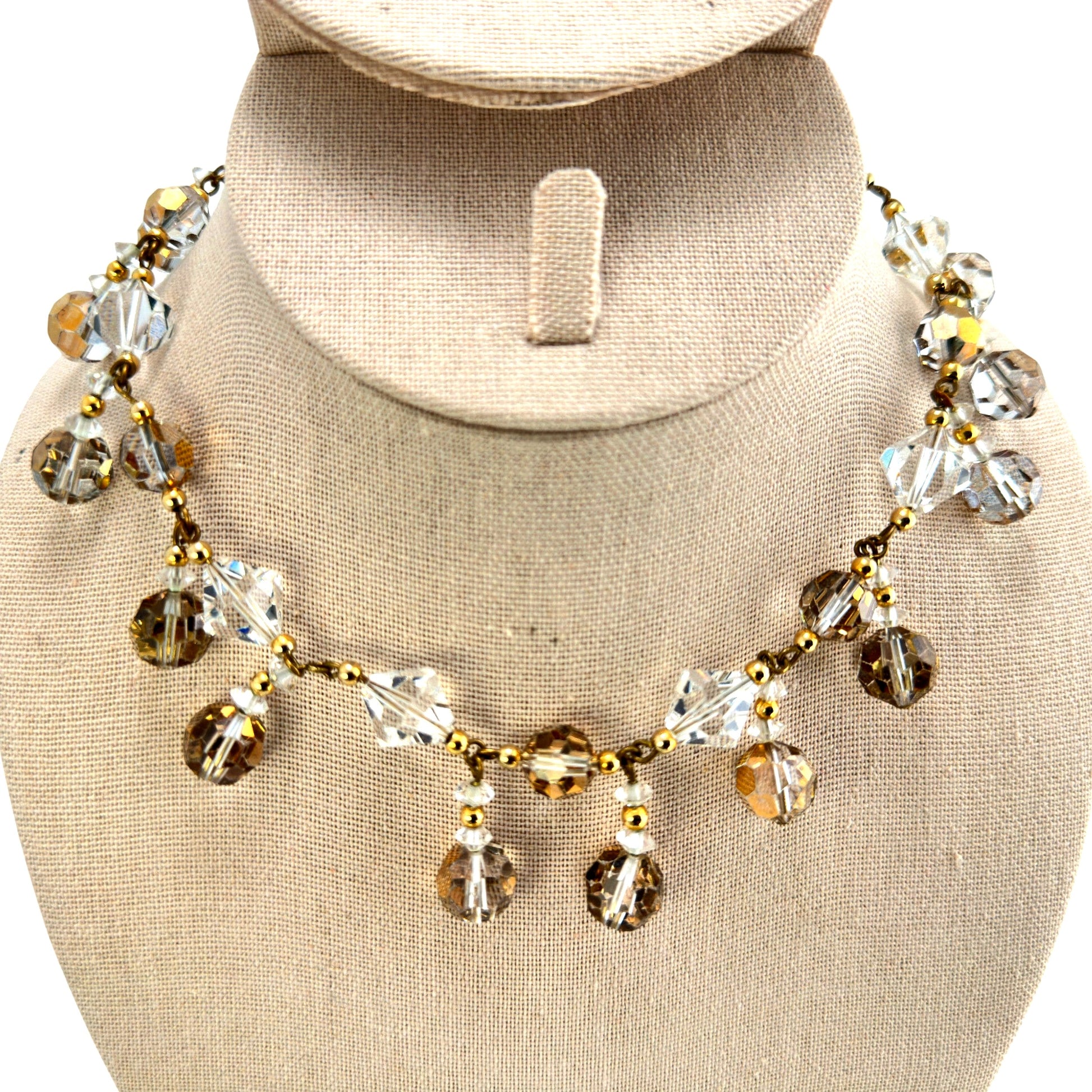 Detail of faceted bicone and round Austrian crystal beads in clear and warm golden-bronze tones wire-linked to gold-tone c...