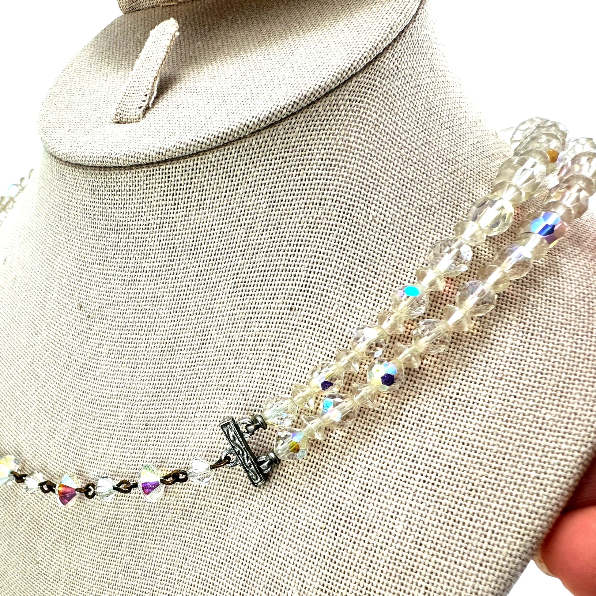 Full length flat lay of two-strand aurora borealis crystal necklace showing bead size graduation and clasp construction