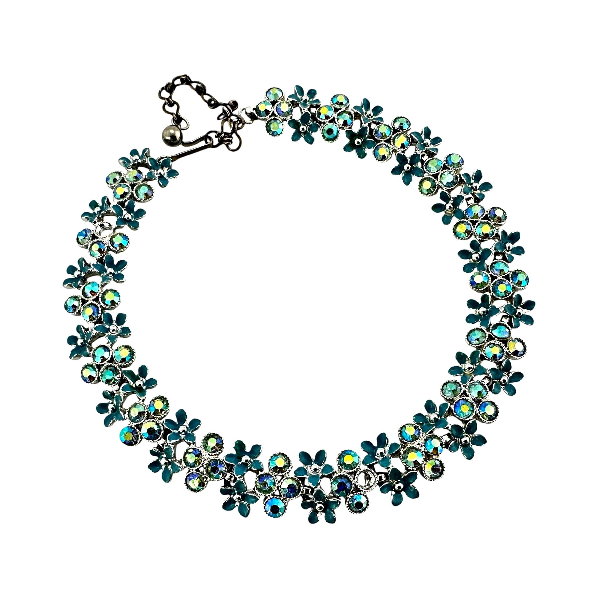 Close-up of alternating teal enamel daisy stampings and iridescent AB rhinestones in prong cup settings on Kramer collar n...
