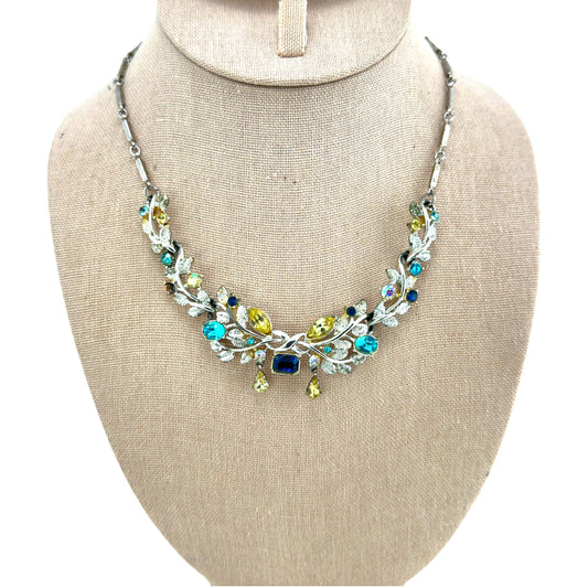 Coro silver-tone foliate bib necklace with sapphire, teal, and citrine rhinestones on flat bar-link chain, front view